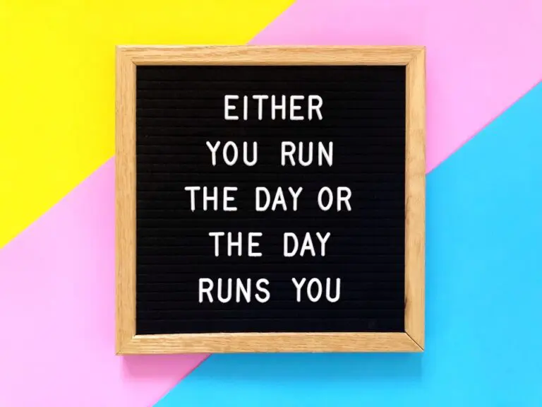 A sign that explains how to achieve peak productivitysays "Either You Run the Day or The Day Runs You"