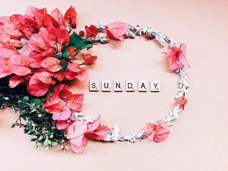 A circle of flowers with scrabble letters spelling Sunday